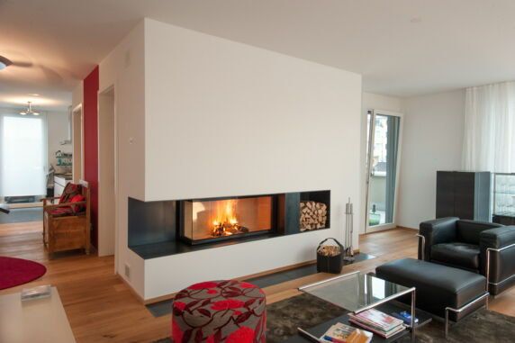 Wohnzimmer mit brennendem Kaminfeuer